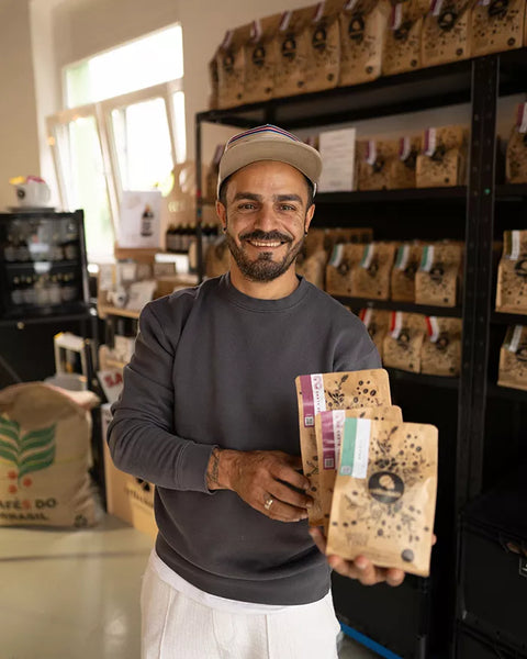 coffeekult Gründer Cem Korkmaz mit Verpackten Kaffee von coffeekult in der Hand.