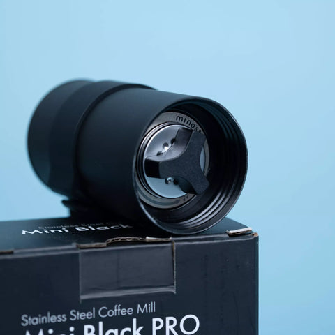 Handkaffeemühle CoffeeKult Mini Black Pro aus schwarzem Metallgehäuse mit Kurbel und kompaktem, reisefreundlichem Design.